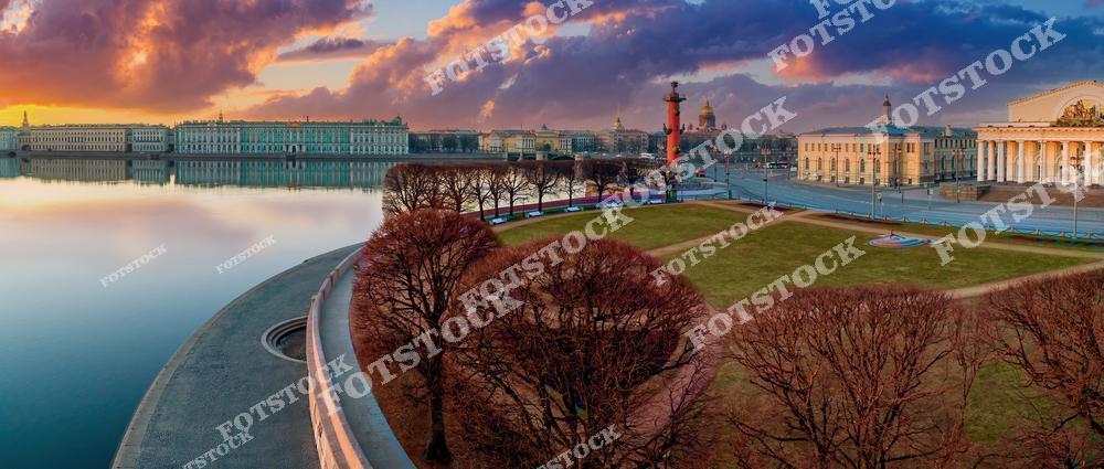 На фотографии изображена Стрелка Васильевского острова в лучах рассветного солнца. Ростральные колонны и здание Биржи подчёркивают историческую значимость этого места. На заднем плане виден Эрмитаж и гладь реки Невы, отражающей краски утреннего неба. Это одно из самых узнаваемых мест Санкт-Петербурга, символ города и его истории.